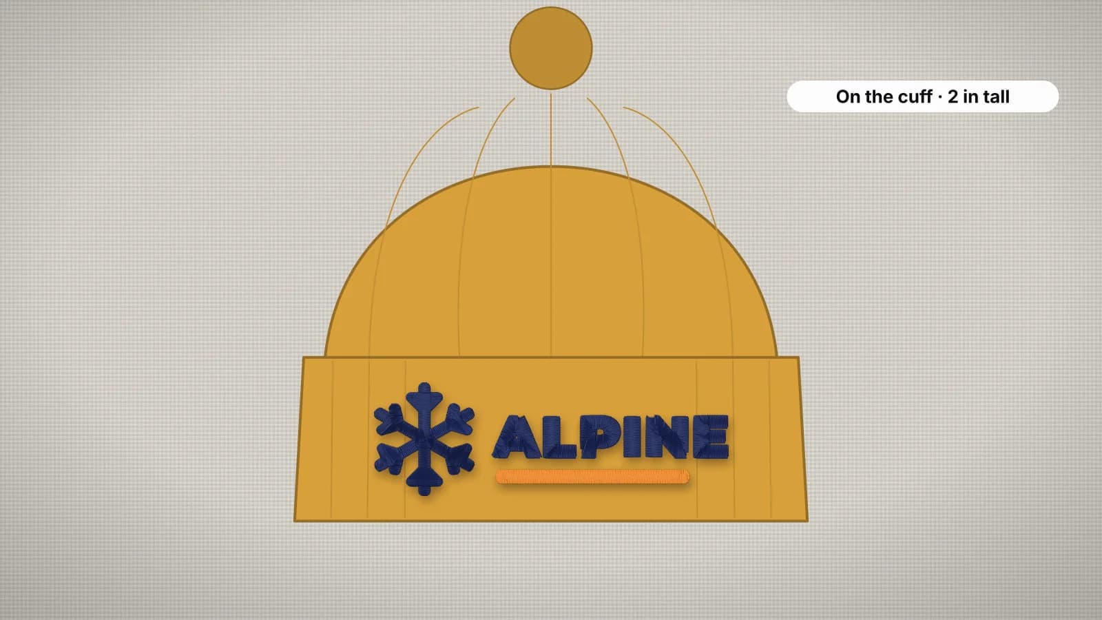 A mustard knit beanie with a logo embroidered on the folded cuff
