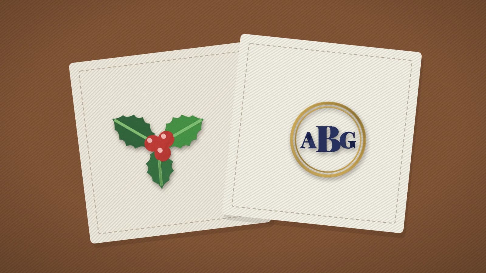 Folded linen napkins embroidered with a holly sprig and a monogram