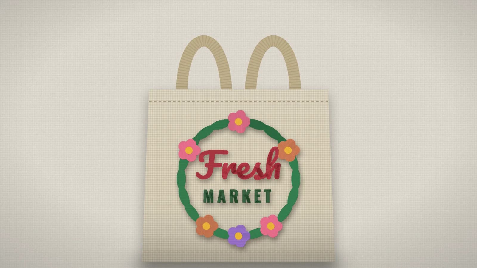 A natural canvas tote bag with a floral Fresh Market wreath embroidered on the front